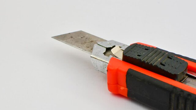 Sharp utility knife on a clear surface, ready for precise cuts for creative projects. Close-up of a stylus on a light background, an essential tool for detailed work.