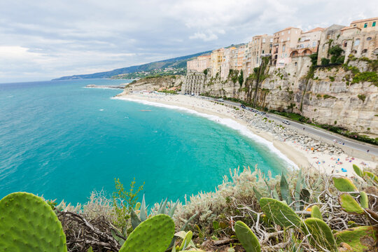 Tropea town and beach coastline of Tyrrhenian Sea with turquoise water, colorful buildings on top of high big rocks, view from Sanctuary church of Santa Maria dell Isola, Calabria, Southern Italy