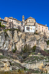 Fototapeta premium View of Cuenca historical center and Cathedral from Huecar River canyon, Spain. Medieval city on rocks under blue sky, no people