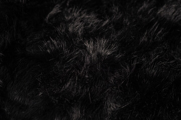 Abstract dark black fluffy plush texture background with soft synthetic fibers showing natural detail © reddish