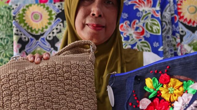 Indonesian crafter proudly showing handmade batik and crochet bags