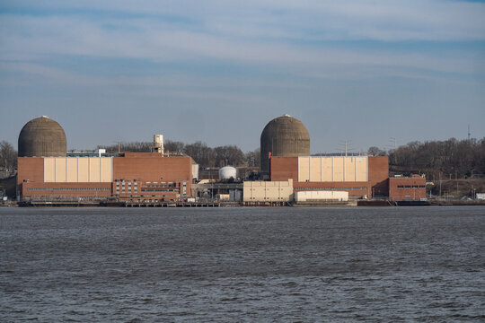 Aerial view of Indian Point Energy Center IPEC featuring two large containment domes and industrial brick buildings along the Hudson River Buchanan, New York, United States.
