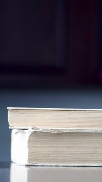 Close up of stacking a pile of old vintage books side view of yellowed paper edges and pages
