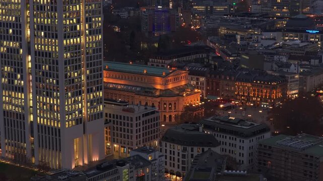 Aerial tripod view of Frankfurt skyline at night, showing illuminated Alte Oper concert hall and modern skyscrapers in the financial district