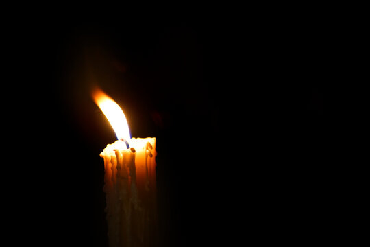 Single Candle Flame in Darkness