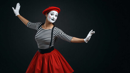 Obraz premium Woman dressed as mime with white face paint and red skirt performing on dark background