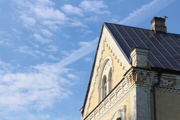 Obraz premium Doles Manor House, Latvia. Historic manor roof detail on a sunny day. Warm sunlight highlights aged roof tiles and traditional architecture, showcasing heritage, texture, and timeless European country