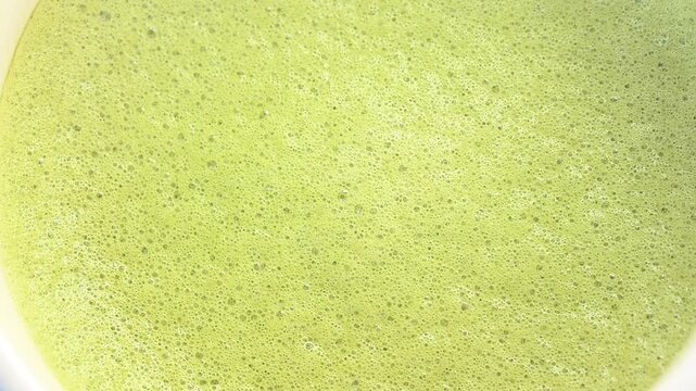 Close up of matcha texture with creamy foam and bubbles. Drink background
