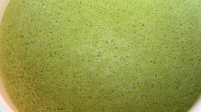 Close up of matcha texture with creamy foam and bubbles. Drink background