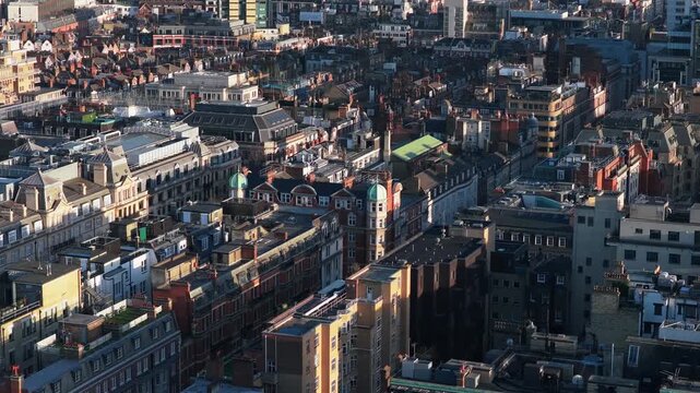 London from above featuring Marylebone, Soho and Covent Garden with city skyline and London Eye revealing on the horizon while sunlight casting long shadows