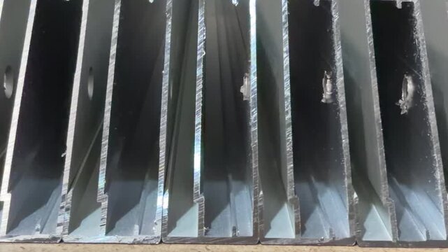Industrial photography: a detailed view of aluminium profiles with a focus on their structural details and finish.