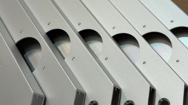 A composition of aluminium profiles with hinge openings, highlighting their potential in creating innovative facade designs.