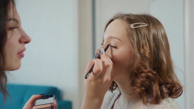 Woman Getting Makeup In Cozy Room, Caucasian Woman Receives Makeup From Friend In Relaxed Environment, Young Woman With Natural Hair Being Assisted By Friend In Tranquil Living Space