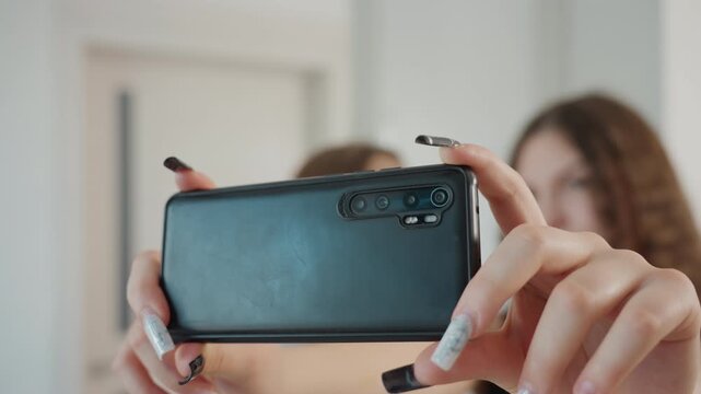 Horizontal Shot By Creators, Steady Hands Capturing Video With Visible Camera Lenses, Artists Filming Social Media Video Using Phone In Relaxed Studio Environment While Holding Horizontally