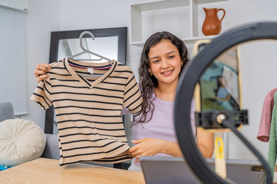 Young woman influencing followers, presenting fashion clothing online