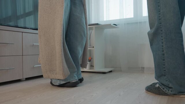 FloorLevel CloseUp Feet Of Parent And Teen In Living Room, Tense Stillness After Argument Near Couch, Denim And Slippers Visible, Family Distance And Tentative Reconciliation Implied