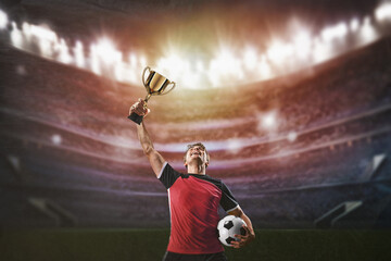 Fototapeta premium soccer players cheering in a large stadium and lifts a winner's trophy upwards - vertical poster concept