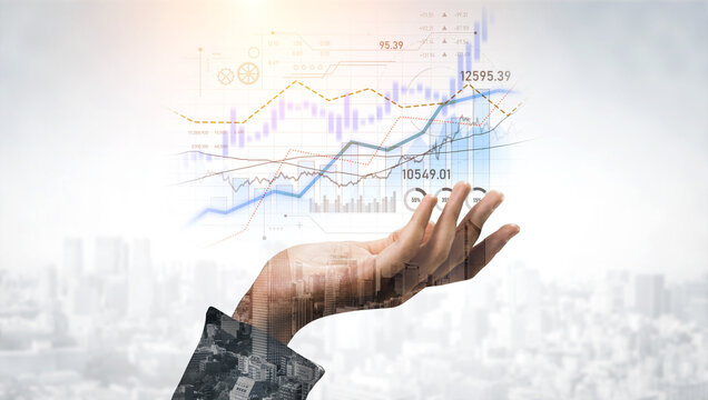 A hand reaches out towards floating digital financial charts showing upward trends, symbolizing growth and dynamic market analysis in an urban setting. Scalp