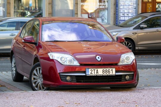 Red Renault Laguna III X91 liftback car parked on street
