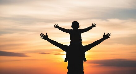 Fototapeta premium Silhouette father carrying child on shoulders at sunset.