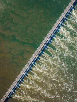 Aerial view of the Eastern Scheldt Storm Surge Barrier with turbulent water currents and foam against the dark sea Vrouwenpolder, Zeeland, Netherlands.