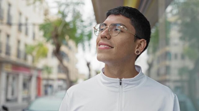 Man wearing glasses and a white zip jacket smiling while looking up on a city street; optimism wonder.