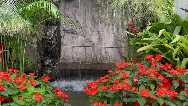 Water cascades down stone into a garden pool