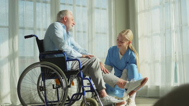 Help support retirement healthcare. Nurse helping old man in wheelchair. Patient and woman in nursing home for medical caregiver. Nurse taking care of paralyzed man in chair for people with disability