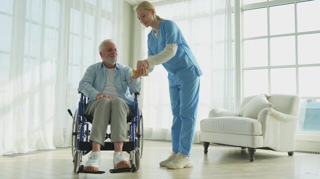 Support rehabilitation healthcare. Nurse helps old man patient in wheelchair picking up dumbbells. Paralyzed man in chair for people with disability doing sports exercise with nurse. Medical caregiver