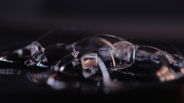 Bubbles Forming Intricate Abstract Patterns Showcasing Iridescent Colors and Delicate Structures on a Dark Reflective Surface
