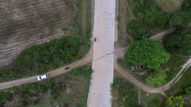 Overhead View Rural Intersection With Vehicle Parked Along Unpaved Path, Tree Canopy Shading Narrow Lane, Small Cottage And Fence Near Roadside, Dirt Tracks Connecting Fields, Subtle Human Activity,
