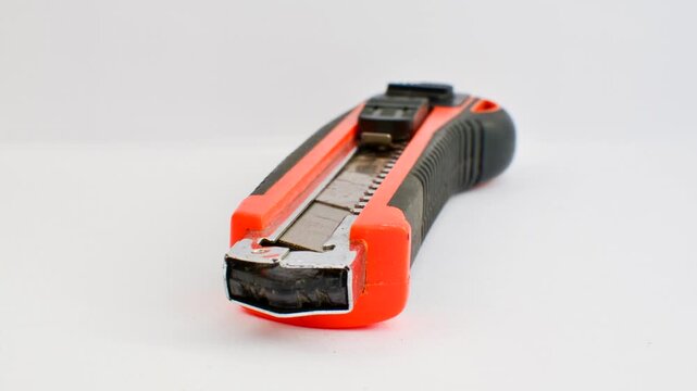 Sharp utility knife on a clear surface, ready for precise cuts for creative projects. Close-up of a stylus on a light background, an essential tool for detailed work.