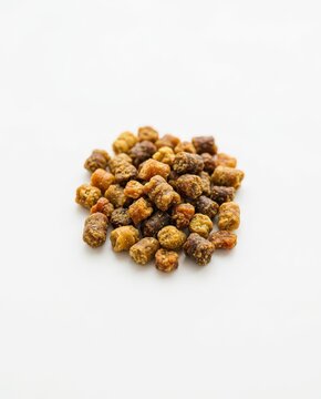 nutritional supplements, close-up view of golden bee bread granules on a white surface