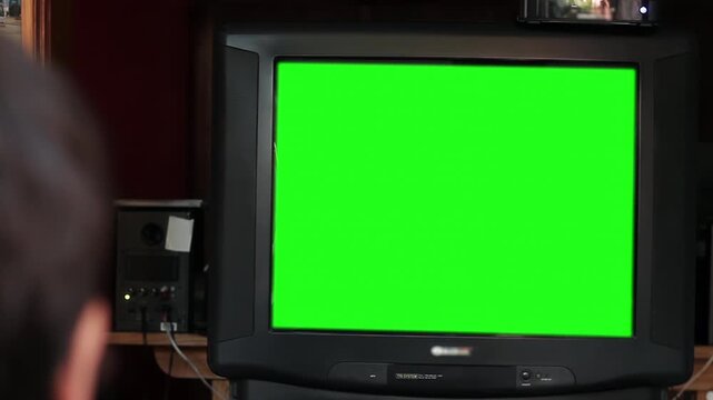 Back View Of A Man Watching An Old Television Green Screen In A Domestic Setting - Zoom Out - 4K