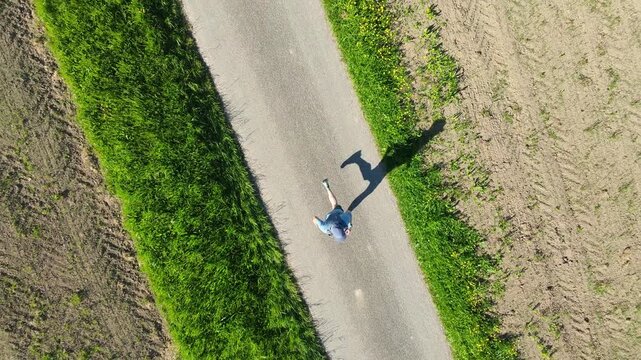 Trail runner seen from bird eye view on a natural path, surrounded by landscape, expressing connection to nature, mental clarity, balance and happiness through movement.