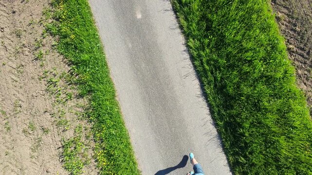 Trail runner seen from bird eye view on a natural path, surrounded by landscape, expressing connection to nature, mental clarity, balance and happiness through movement.