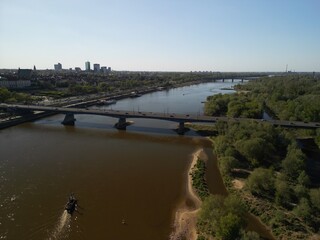 Warszawa - Polska - panorama Warszawy wykonana dronem. Rzeka Wisła, kościół, wieżowce, bloki, ulice w słoneczny dzień © Konrad