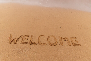 Business hello and welcome concept. Concept word Welcome written on beautiful ocean sea sand beach. Beautiful ocean sand beach background, copy space. Business hello and welcome concept. © Dzmitry