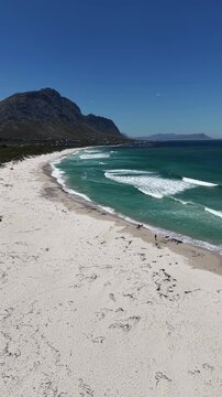 White sandy beach at Betty&rsquo;s Bay, South Africa, captured by drone from above, vivid summer colors, empty coastline, wide horizon, fresh air, calm atmosphere and sense of freedom.