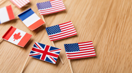 Obraz premium Handmade paper international flags scattered over clean light oak wooden desk. Creative children educational craft showing global unity concept. Flat lay background providing massive empty copy space