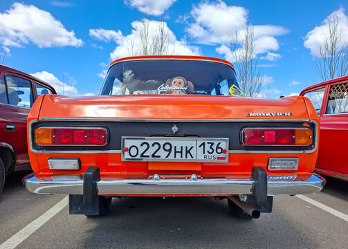 VORONEZH, Russia - April 25, 2026.Bright orange Moskvich car with Cheburashka toy at Russian classic car show under blue sky