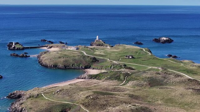 Aerial Video Llanddwyn Island. Ynys Llanddwyn is a tidal island just off the coast of Anglesey in North Wales. When the tide is in, the island is almost entirely cut off from the mainland.