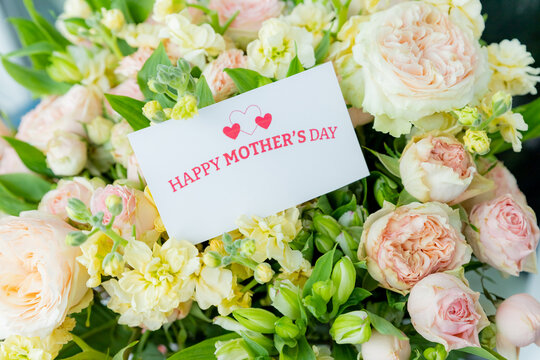 Happy Mother's Day Card and Bouquet. Flowers background. spring holiday concept.heart and blossoms.beautiful bright bouquet with a gift card with the text inscription.sweet wish concept