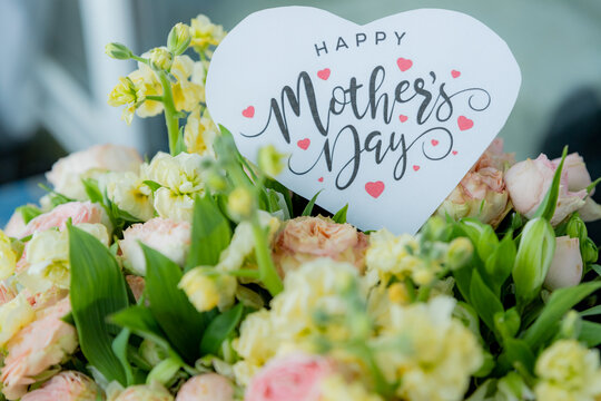 Happy Mother's Day Card and Bouquet. Flowers background. spring holiday concept.heart and blossoms.beautiful bright bouquet with a gift card with the text inscription.sweet wish concept