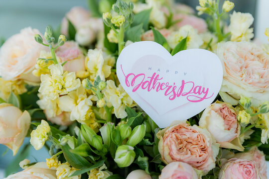 Happy Mother's Day Card and Bouquet. Flowers background. spring holiday concept.heart and blossoms.beautiful bright bouquet with a gift card with the text inscription.sweet wish concept