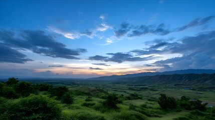 Naklejka premium Panoramic view of lush green valleys and rolling mountains bathed in the soft ethereal light of dawn or dusk
