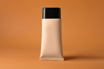 Naklejka premium Skin foundation in tube on beige background, closeup