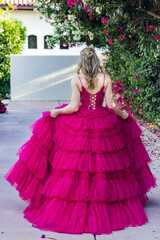 Fototapeta premium teen girl showing off the back detail of a beautiful pink party dress