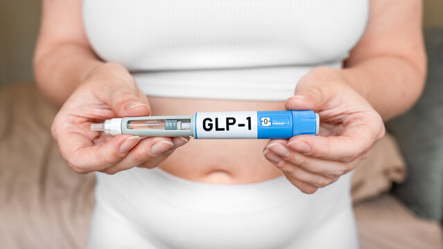 GLP-1 injection pen in female hands near abdomen, weight loss and diabetes treatment concept