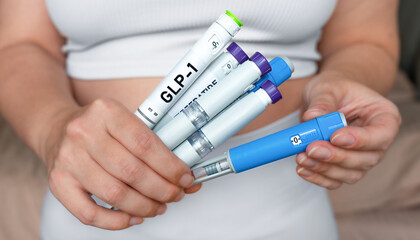 Obraz premium Woman holding multiple GLP-1 injection pens, weight loss and diabetes treatment concept